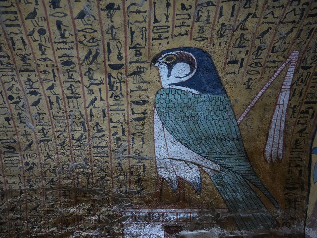 Detailed wall painting of the falcon god Horus surrounded by hieroglyphs in the Tomb of Roy
