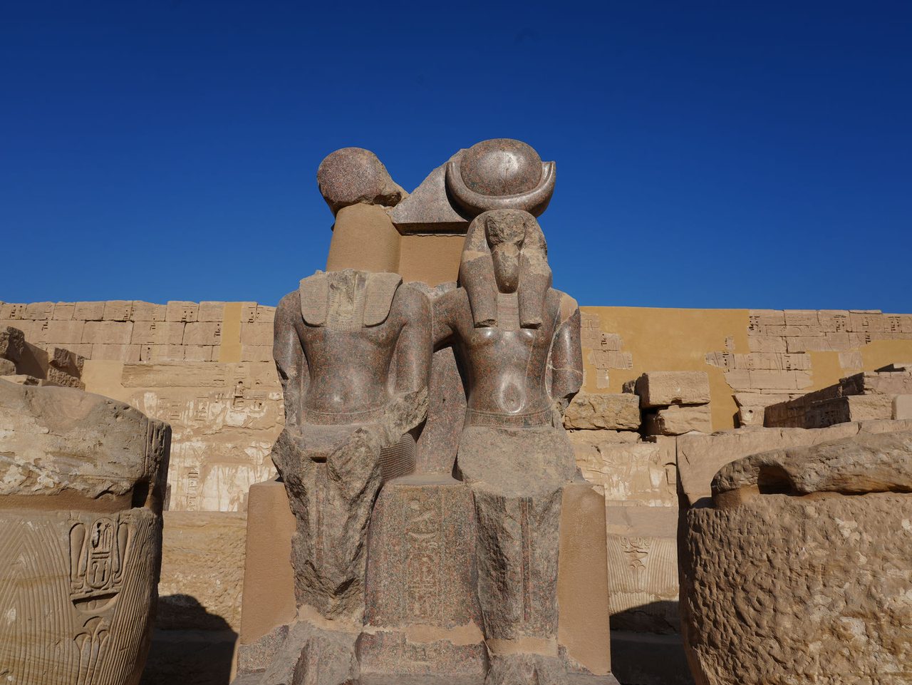 The red granite statue of Ramesses III and Thoth inside the first courtyard of Medinet Habu