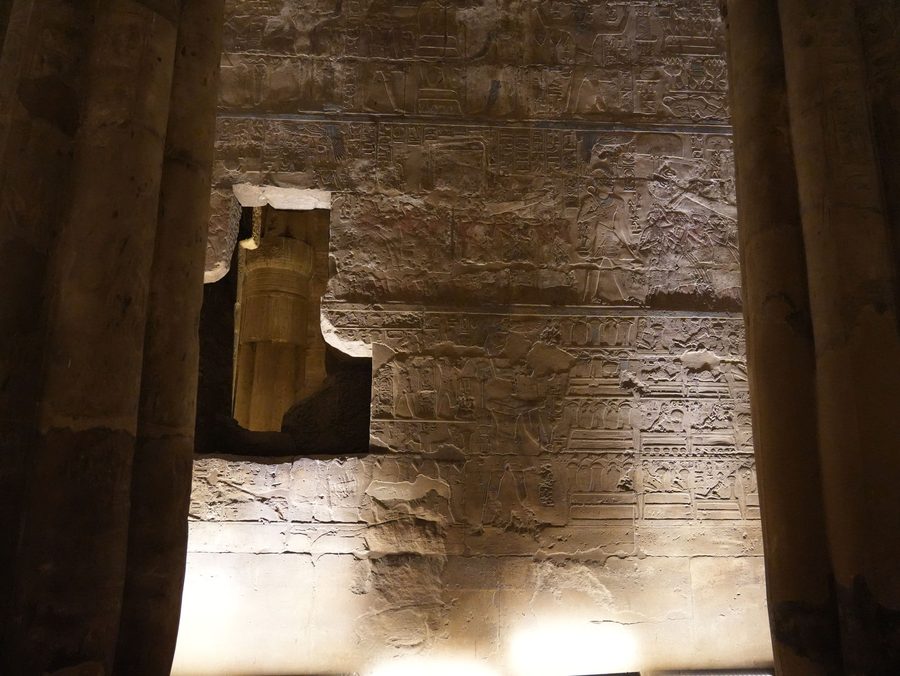 The illuminated hieroglyphs and relief carvings on the inner walls of Luxor Temple at night