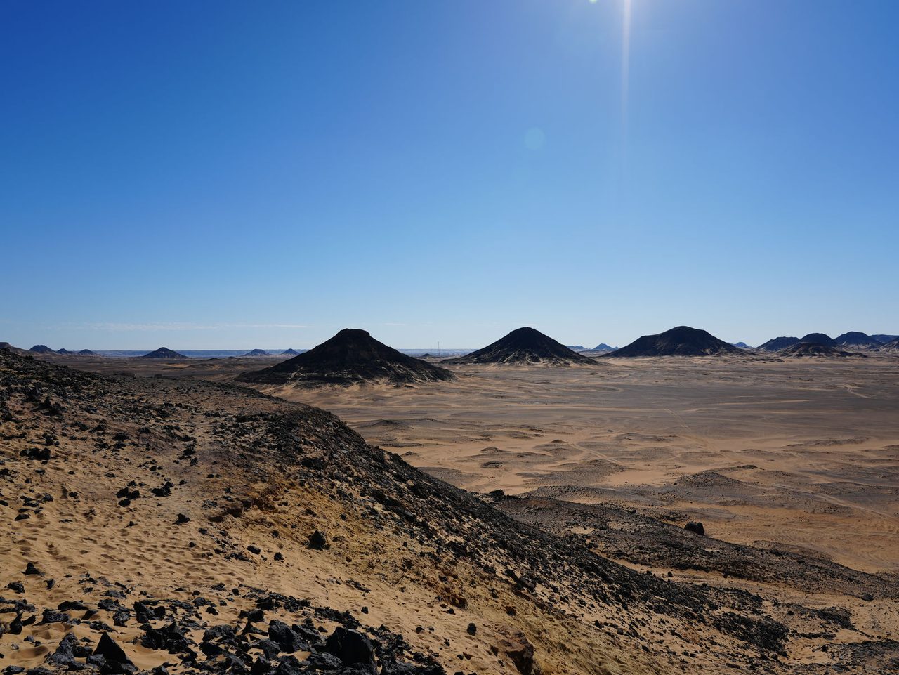 Sun-drenched horizons stretching across the vast Black Desert