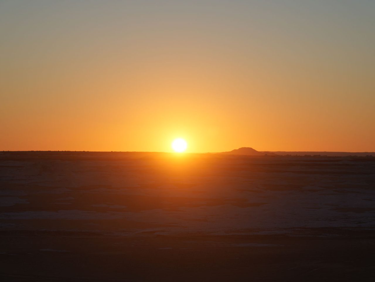 The sun rising over the pristine horizons of the White Desert