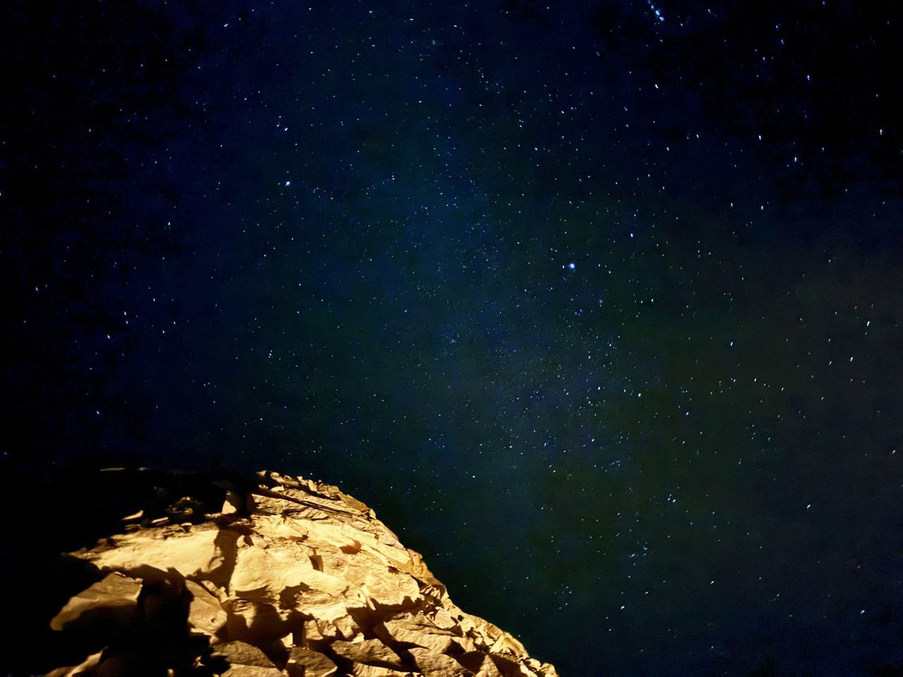 Illuminated white rocks beneath the infinite stars of the White Desert