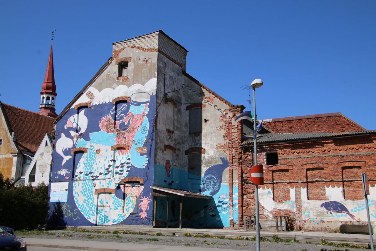 A colorful mural of a captain on an old building