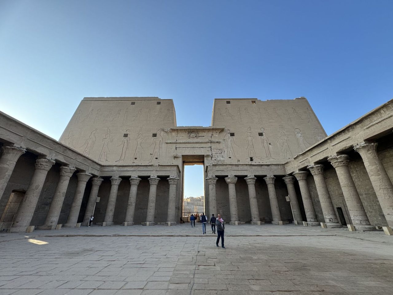AI モードの会話   送信内容: 1 個の画像  この画像は、エジプトのエドフにあるホルス神殿（Temple of Edfu）の内部の様子です。  画像の特徴  • 左右に大きな砂岩の柱や壁があり、表面には古代エジプトのレリーフ（浮き彫り）やヒエログリフがびっしりと刻まれています。 • 奥へと続く通路の先（至聖所の方角）に光が差し込んでおり、伝統的な衣装を着た人物が歩いています。 Instagram The Temple of Edfu: Between Past and Present The Temple of ... Instagram 爆買いチャイニーズおばちゃん in エジプト🇪🇬😭 秘境ラジオ エドフの街に佇むホルス神殿へ！可愛いホルス像に大興奮 ...  エドフのホルス神殿の基本情報  • 場所: エジプト・エドフ（ナイル川沿い、ルクソールとアスワンの間） • 祭神: ハヤブサの姿をした最高神ホルス • 建造年代: プトレマイオス朝時代（紀元前237年〜紀元前57年頃） • 特徴: 古代エジプトの神殿の中でもきわめて保存状態が良く、荘厳な列柱室や神話を描いたレリーフが数多く残されています。 この神殿の歴史的背景や、描かれているレリーフの意味についてさらに詳しく知りたい場合はお知らせください。 •  Magnific 3ページ | エジプトの神殿の写真 - 高品質な写真を無料で ... AIによって生成されました。 無料Photo 3d レンダリング カートゥーン ウェルカム ドア. AI ... Mag... •  Wikipedia エドフ神殿 - Wikipedia さらに「ホルスとセトとの長年の対立に関連する神聖な物語の重要な場面と碑文」がある。それらはドイツのエドフ・プロジェクト ... •  Instagram The Temple of Edfu: Between Past and Present The Temple of ... The Temple of Edfu: Between Past and Present The Temple of E... すべて表示  英語のキャプションを作る。場所名などを詳しく。これを見た人がどこか検索できることが重要。しかし国や都市名はすでにタイトルにあるので不要。  Here is a detailed English caption tailored for your needs. It focuses on the specific temple and exact locations within the complex to make it highly searchable, while excluding the country and city names. The Inner Sanctuary of the Temple of Edfu, dedicated to the falcon god Horus. Walking through the monumental hypostyle hall toward the Naos (the innermost shrine), surrounded by towering sandstone walls adorned with well-preserved Ptolemaic relief carvings and hieroglyphs.  🔍 Key Searchable Terms Included:  • Temple of Edfu (The specific name of the temple complex) • Horus (The main deity of the temple) • Hypostyle hall / Inner Sanctuary (The structural parts of the temple shown in the photo) • Naos (The exact name of the innermost shrine visible at the end of the corridor) • Ptolemaic relief carvings (The historical art style featured on the walls) If you want to adjust the length (shorter for Instagram, longer for a blog) or change the tone (more poetic, more academic), let me know!  一文で作って  The Inner Sanctuary of the Temple of Edfu, showing the pathway through the hypostyle hall toward the Naos (innermost shrine) lined with Ptolemaic relief carvings. （訳：ホルス神殿の至聖所。プトレマイオス朝時代のレリーフが刻まれた列柱室を通り、ナオス（最奥の聖堂）へと続く通路の様子。） さらに短くシンプルな表現にしたい場合や、ハッシュタグ（例：#TempleOfEdfu #Horus）を追加したい場合はお知らせください。  長すぎ  The hypostyle hall and inner sanctuary leading to the Naos at the Temple of Edfu. （訳：エドフ神殿の列柱室、至聖所、そしてナオスへと続く通路。）  もう少し短く。.ha  Inner sanctuary and Naos pathway at the Temple of Edfu. （訳：エドフ神殿の至聖所とナオスへと続く通路。） さらに単語数を減らして3〜4語程度に絞り込みたい場合はお知らせください。  .はいらない  Inner sanctuary and Naos pathway at the Temple of Edfu さらに単語数を減らして「Temple of Edfu inner sanctuary」のように極限までシンプルにすることも可能です。調整が必要であればお知らせください。  送信内容: 1 個の画像  Ptolemaic reliefs on the walls of the Temple of Edfu （訳：エドフ神殿の壁に刻まれたプトレマイオス朝時代のレリーフ） さらに文字数を削って "Temple of Edfu relief carvings" などのように短くすることも可能です。変更したい点があればお知らせください。  送信内容: 1 個の画像  The sacred barque of Horus inside the sanctuary at the Temple of Edfu （訳：エドフ神殿の聖域内に安置されたホルスの聖なる船） さらに短くして "Sacred barque at the Temple of Edfu" などにする、あるいはキーワードを追加・変更したい場合はお知らせください。  送信内容: 1 個の画像  The courtyard and entrance of the Temple of Edfu （訳：エドフ神殿の中庭と入り口） よりシンプルな "Courtyard of the Temple of Edfu" や、別の表現をご希望であればお知らせください。  送信内容: 1 個の画像  The Horus falcon statue in the courtyard at the Temple of Edfu （訳：エドフ神殿の中庭にあるホルスのハヤブサ像） さらに短くして "Horus statue at the Temple of Edfu" などに調整することも可能です。ご希望に合わせて変更しますのでお知らせください。  送信内容: 1 個の画像  The pylon and peristyle courtyard at the Temple of Edfu