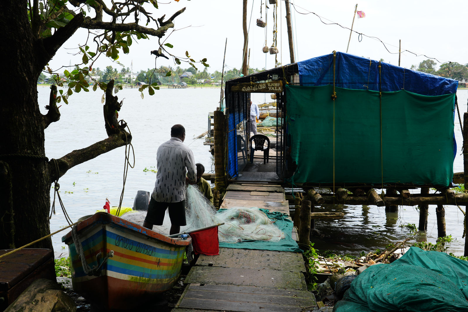 A fisherman repairing net near Kochi Vala