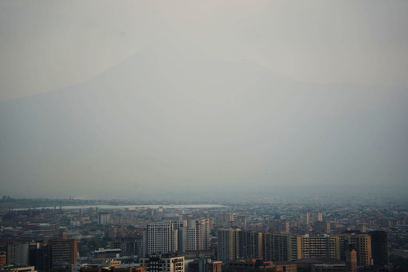 The hazy silhouette of Mount Ararat over the city