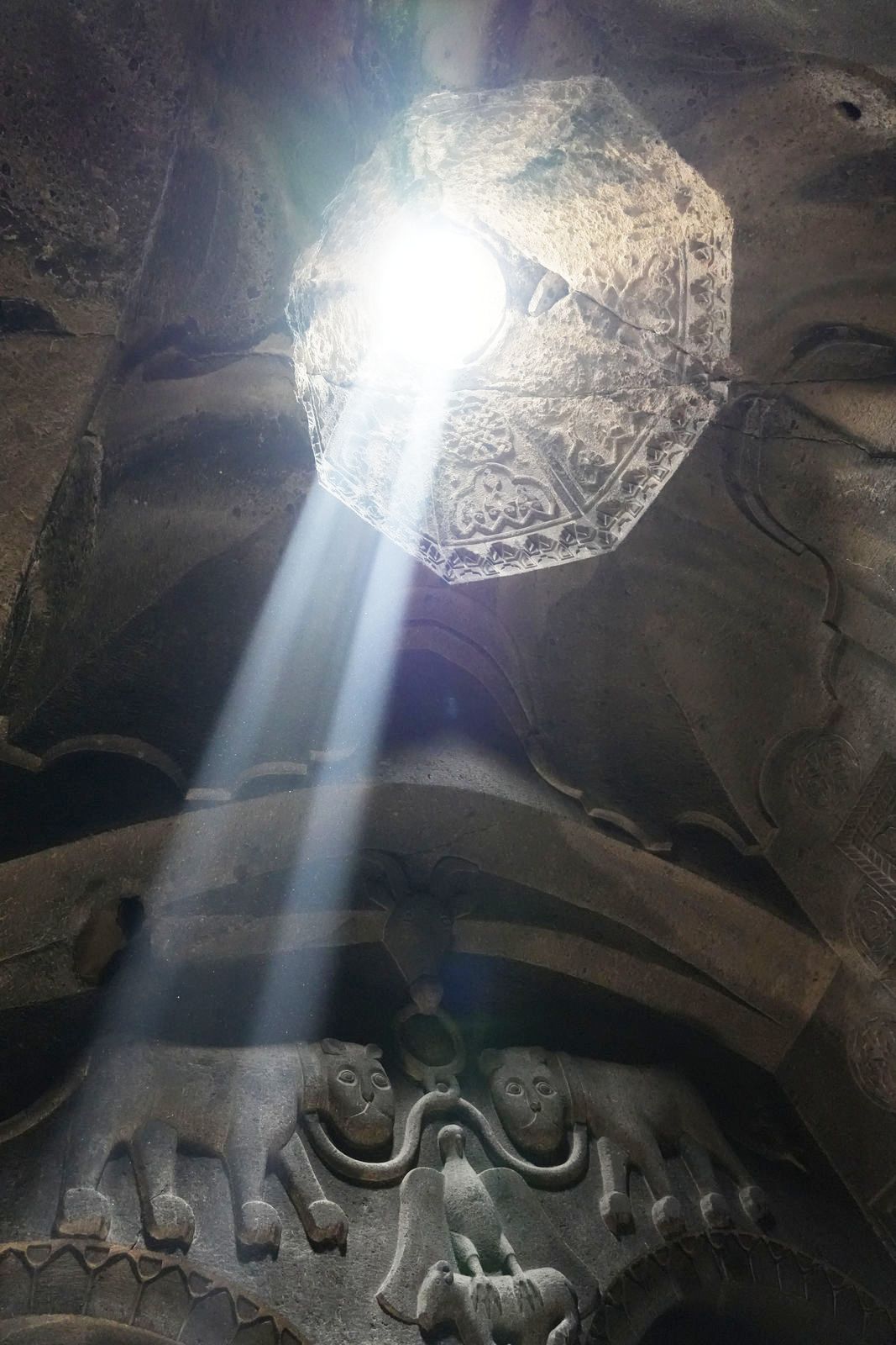 The Proshian family crest illuminated by a beam of light inside Geghard