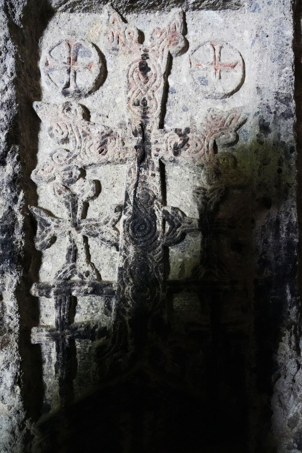 An ancient stone Khachkar carved into the wall at Geghard