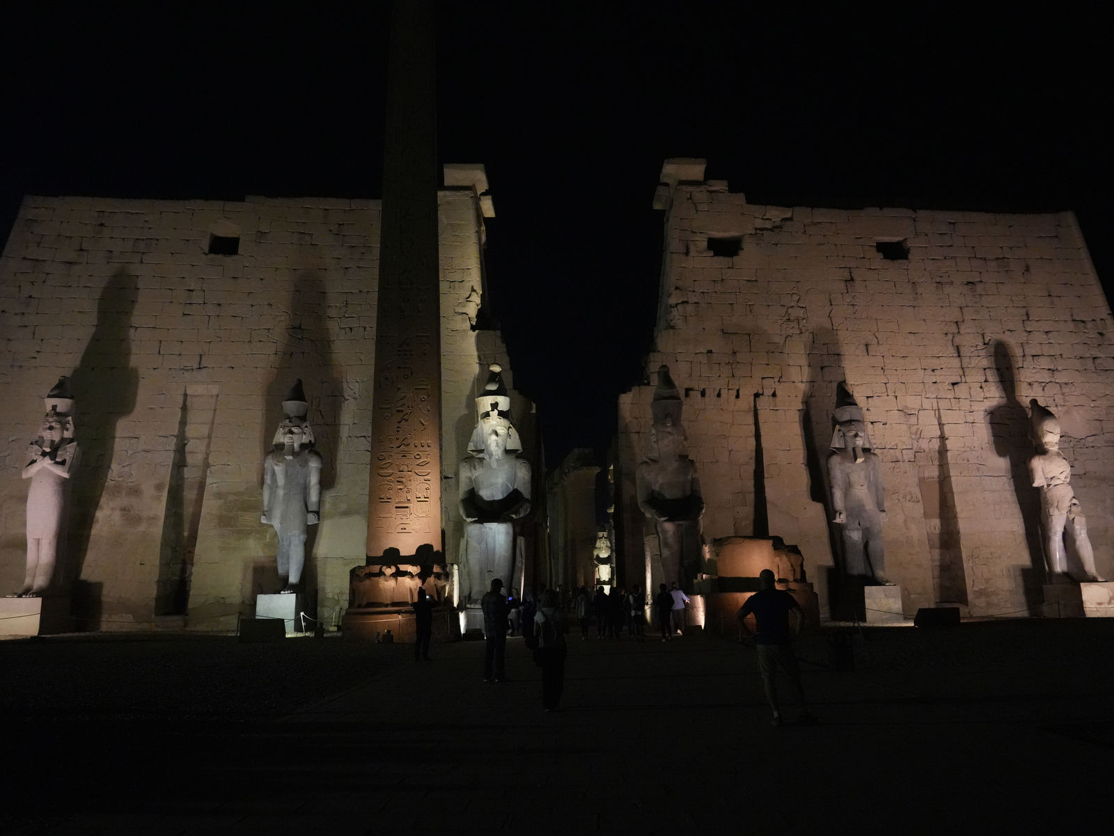 The illuminated first pylon and the obelisk of Ramesses II at night in Luxor Temple