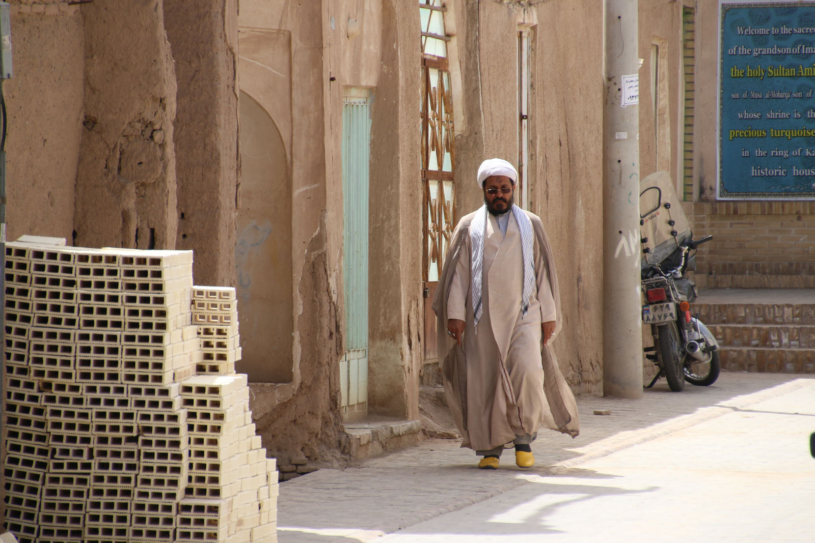 A clergyman walking near Sultan Amir Ahmad Shrine