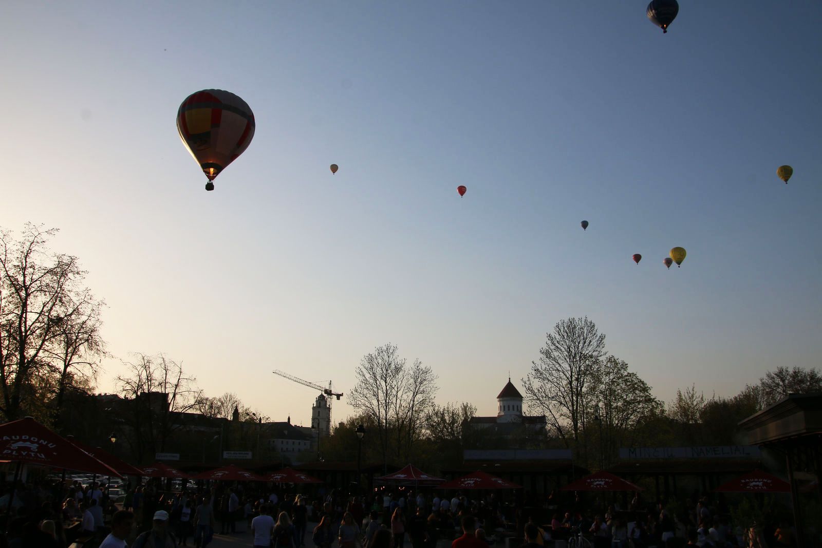 Hot air balloons floating in the evening sky over the city
