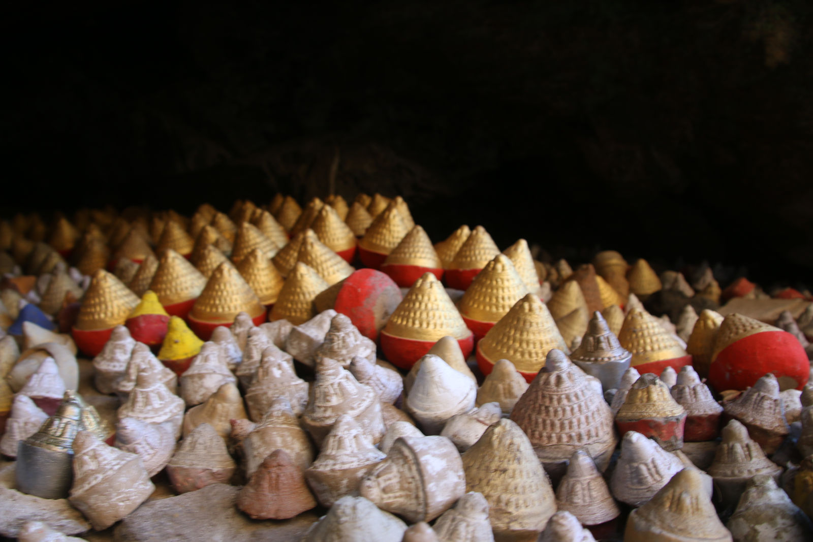 Traditional tsa-tsa clay offerings placed inside a sacred cave