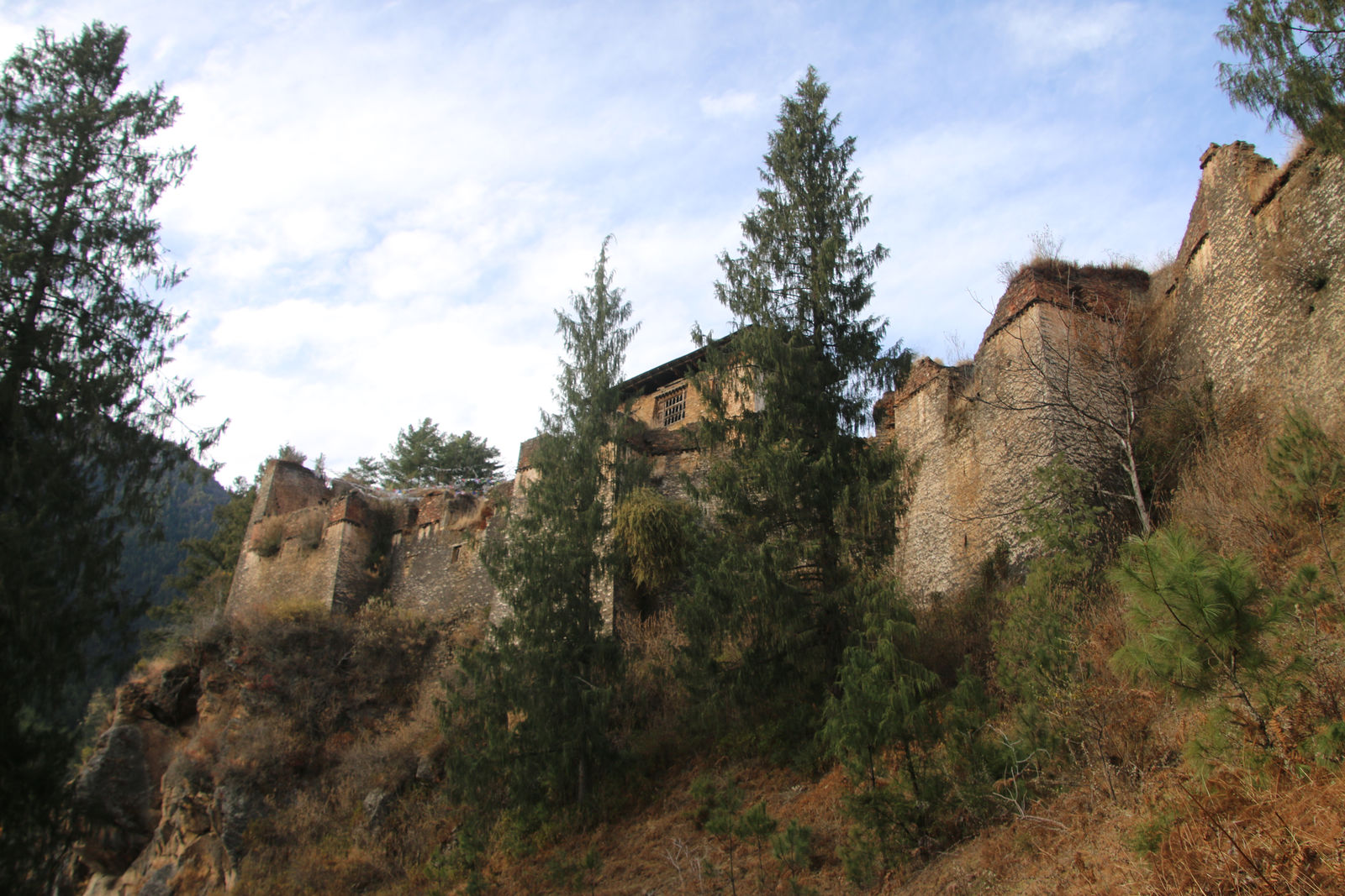 The towering stone walls of the Drukgyel Dzong fortress ruins atop a hill