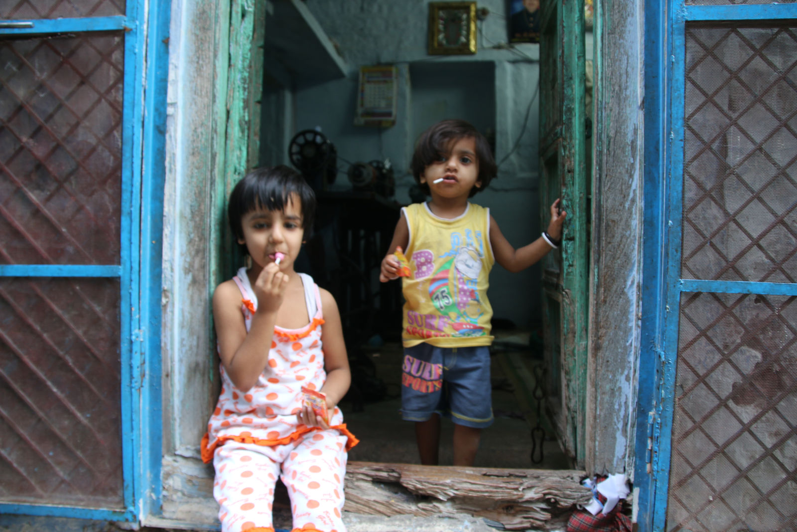 Children waving from a window in the Blue City